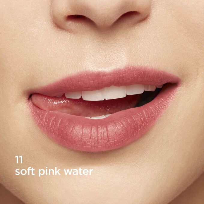 Primer plano de unos labios sonriendo para mostrar la textura y el color del labial rosa en el tono de piel